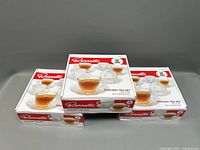 Set of three Ronnelli Tuscany Glass Tea Sets in original boxes, stacked side by side
