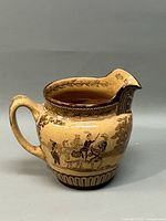 Side view of Royal Doulton Ellington Tournament pitcher showing handle, spout, and detailed medieval knight scene artwork.