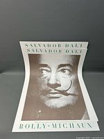 Five Salvador Dali gallery posters stacked showing front portrait of Dali and text with 'Rolly-Michaux' print.