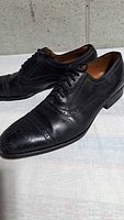Pair of black leather Oxford shoes angled side view