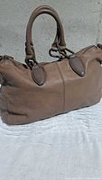 Front angled view of taupe Liebeskind Berlin leather handbag showing handles and body