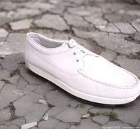 Lateral view of right shoe showing white leather upper and moc-toe stitching