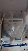 Serger under plastic dust cover on shelf
