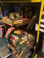 Shelf with cardboard box of loose toys, packaged action figure, stacked board games