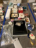 Full view of assorted jewelry boxes, faux pearl piece, cords, charms