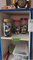 Upper shelf showing three jars of buttons