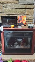 Heat Surge fireplace, EdenPure heater on top, manual, remotes visible