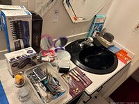 Overview of hair dryers, grooming tools, pill organizers and BP monitor on countertop