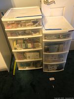 Two plastic drawer organizers filled with assorted sewing materials