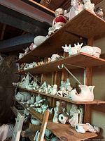 Shelves filled with unpainted bisque figurines including Santa, sleigh, reindeer, animals and children