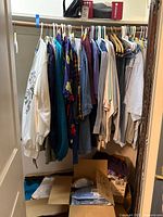 Hanging shirts, sweatshirt, hanger rod, boxes below with slippers