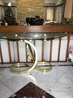 Front view of console table showing glass top and gold-tone ribbon base