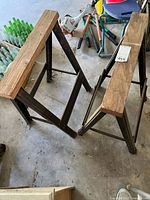 Pair of wood-topped metal sawhorses, angled view