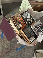 Top view of bag showing multiple paperback books including Beyond Reason, The Black Echo, Bitter Blood