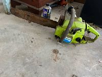 Left side view showing full chainsaw, bar, chain, and dirt/rust