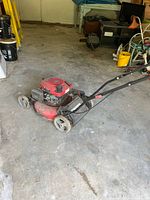 Full view of red PowerSmart push mower showing deck, engine and handle