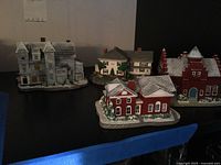 Four Rockwell Main Street house figurines grouped on shelf