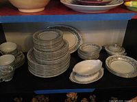 Full view of stacked dinnerware showing plates, cups, serving pieces