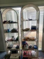 Front view of both white wicker arched-top bookshelves showing shelves and condition; contents not included