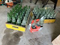 Group of Sprite and Coke bottles in wooden crates and cardboard carrier