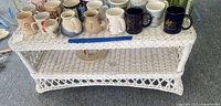 Full view of white wicker coffee table with mugs on top