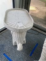 Full view of white wicker elephant table with overlay on top