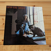 Front cover of Carole King Tapestry album featuring Carole King sitting by a window with a cat.