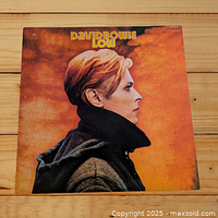 Front cover of the David Bowie Low vinyl LP album showing Bowie's profile against an orange background.