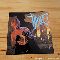 Front cover of David Bowie's Let's Dance LP showing Bowie with boxing gloves and the album title.
