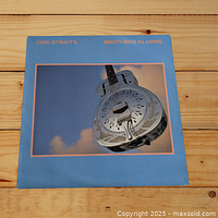 Front cover of Dire Straits Brothers in Arms LP vinyl showing resonator guitar illustration on blue background.