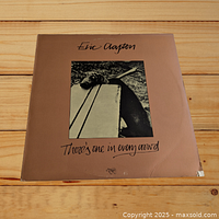 Front cover of Eric Clapton LP titled 'There's One in Every Crowd' with slight damage on edges and corners.
