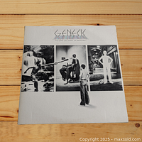 Front cover of Genesis LP 'The Lamb Lies Down on Broadway' showing artwork with band name and album title.