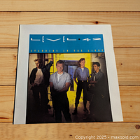 Front cover of Level 42 LP 'Standing in the Light' showing band members and album title.