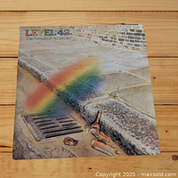 Front cover featuring colorful rainbow over cobblestone surface with broken bottle near a storm drain.