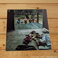 Front cover of Little River Band Self Titled LP record showing band members and casual clothing on wooden dock.