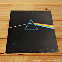 Front of the vinyl LP gatefold cover featuring the iconic prism and rainbow light design on black background. Shows wear and scuffing around edges.