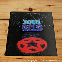 Front cover of the Rush 2112 vinyl album showing the title and red star emblem against black background.