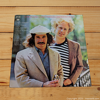 Front cover of Simon and Garfunkel 'Greatest Hits' vinyl LP featuring portrait of Simon and Garfunkel outdoors.