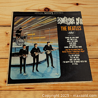 Front cover of The Beatles LP "Something New" showing band members on stage with instruments and track listing on the front sleeve.