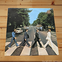 Front cover of Abbey Road album showing The Beatles walking on zebra crossing.