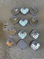 All 12 motion sensor LED night lights arranged on a surface showing front and back sides.