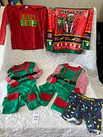 Seven adult Christmas-themed clothing pieces displayed: red 'Merry Xmas' pajama top, Iron Maiden holiday sweater, two green elf one-piece pajamas, and two pairs of novelty underwear with Christmas light prints.