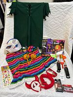 Photo showing all costume and party items including green tunic, serape, face mask, maracas, headbands, nail set, fake lashes, temporary tattoos, pumpkin carving tools and kits