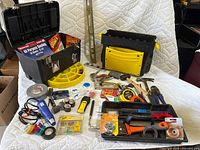 Wide view of assorted hand tools including two plastic toolboxes, fasteners, tapes, and hand tools.