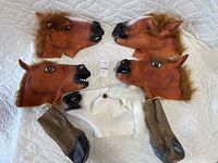 Five adult size horse head masks (four brown, one white) made of rubber or latex and one pair of horse hooves.