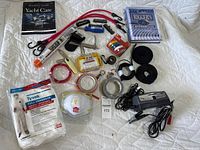Overhead view showing all items in the marine maintenance kit including tools, protective gear, tapes, cords, case, and books.