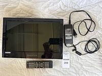 Proscan 15.6 inch LED TV/DVD combo front view with remote and power cord