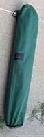 Green polyester carrying case for folding camp cot with drawstring closure and Slumberjack label.