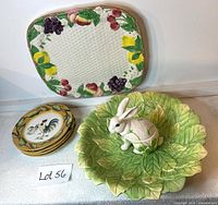 Overview of all items: white rabbit chip and dip bowl with green and yellow leaf-shaped base, rectangular basketweave serving platter with colorful fruit edging, and four rooster motif salad plates stacked