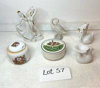 Front view of six porcelain items: dancing couple, small geese figurines, and trinket boxes.